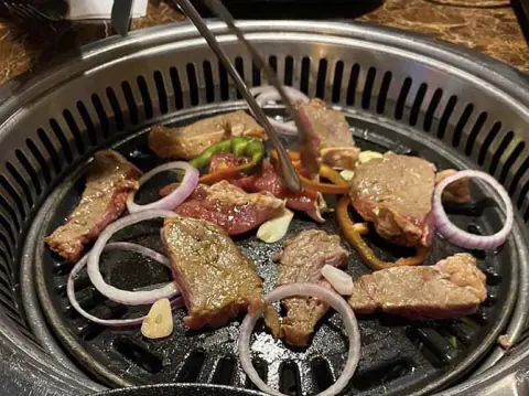 Carne asándose en la parrilla coreana de la mesa